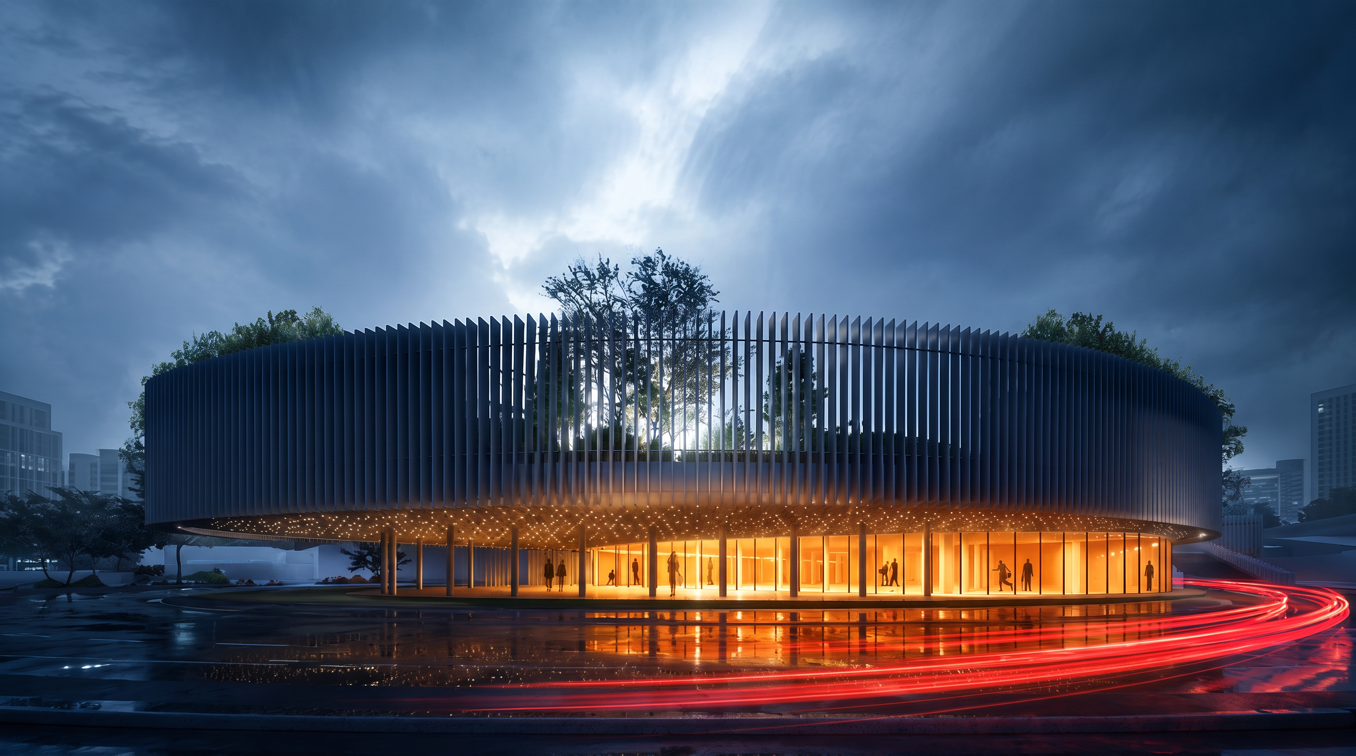 Night view of the louvred elliptical hall at Online Retail Services, Vora, its glazed ground floor glowing beneath roof trees